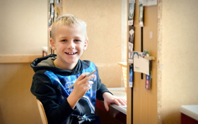 Leerling zit gedraaid op zijn stoel