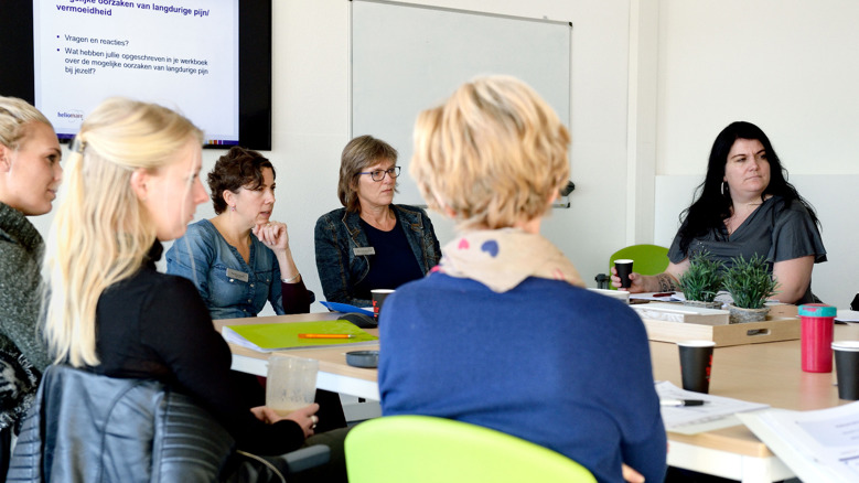 Therapeuten en cliënten zitten rond een tafel