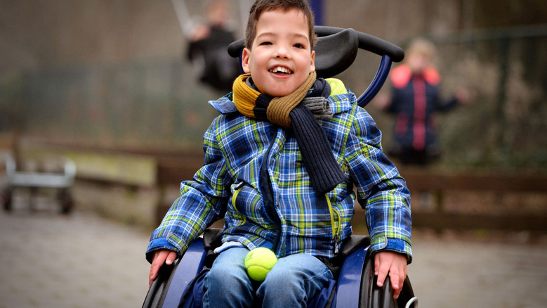 Lachende leerling in een rolstoel